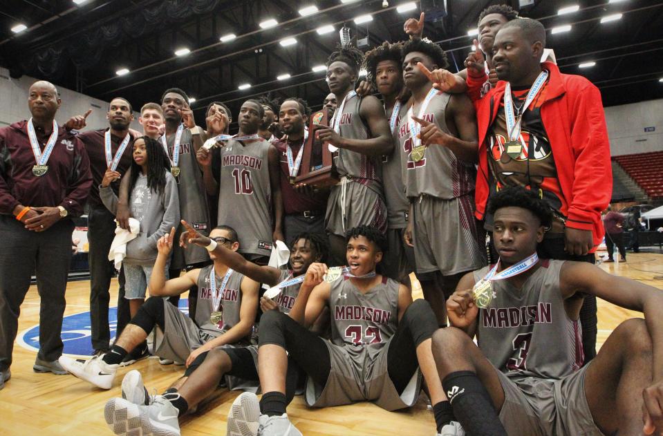 Madison County's basketball team celebrates a Class 1A state championship with a 62-60 overtime victory against Wildwood at the RP Funding Center in Lakeland on Tuesday.