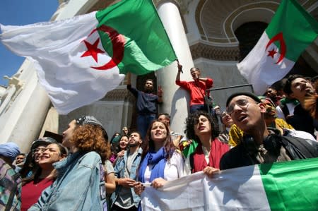 FILE PHOTO: Demonstrators hold flags during anti government protests in Algiers