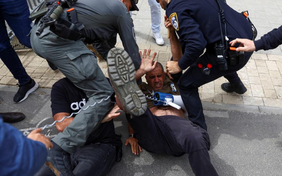 Police detain a demonstrator during the "Day of Shutdown" protest on Thursday in Tel Aviv - RONEN ZVULUN/REUTERS