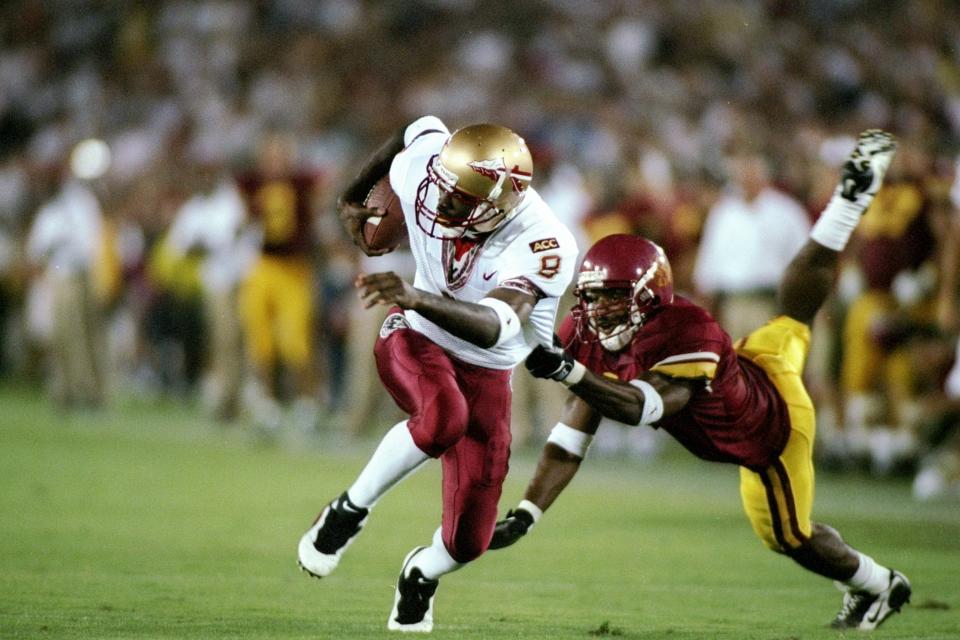 6 Sep 1997: Damian Harrell of Florida State carries the football while escaping the grasp of defensive back Daylon McCutcheon (right) of the USC Trojans during the Seminoles 14-7 win at the Memorial Coliseum in Los Angeles, California.