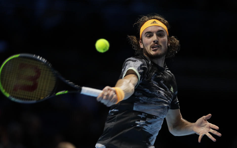Stefanos Tsitsipas of Greece plays a return to Roger Federer of Switzerland during their ATP World Tour Finals semifinal tennis match at the O2 Arena in London, Saturday, Nov. 16, 2019. (AP Photo/Kirsty Wigglesworth)