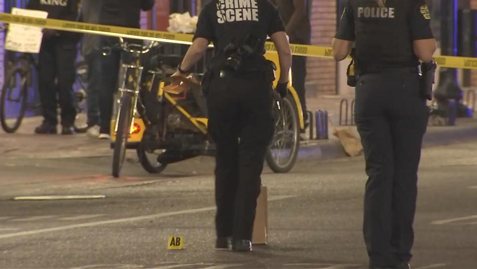 Police gather evidence at the scene of a shooting on Central Avenue in downtown Orlando