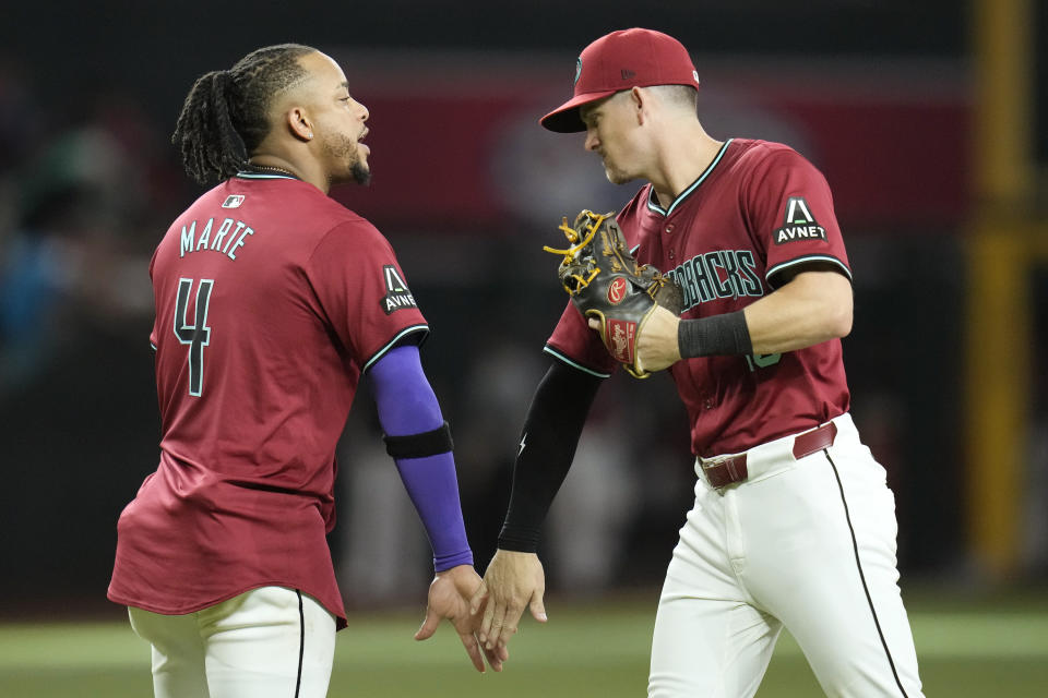 Arizona Diamondbacks' Ketel Marte (4) and Kevin Newman, right, celebrate after the final out a baseball game against the Oakland Athletics, Saturday, June 29, 2024, in Phoenix. The Diamondbacks won 3-0. (AP Photo/Ross D. Franklin)