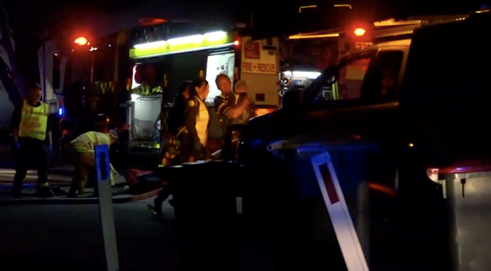 Crews carry a child outside the scene of a house fire in Bargo, NSW.