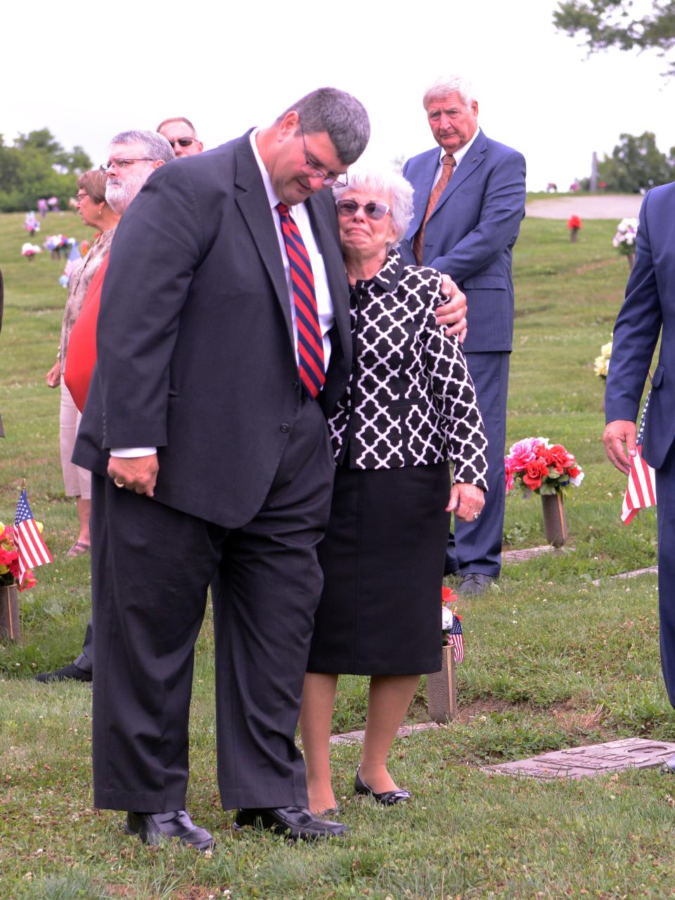 Funeral director Ty Dierkes, of Bolin-Dierkes Funeral Home in Zanesville, consoles Martha Lentz following the services for her husband, retired Zanesville Assistant Fire Chief Robert Lentz, at Zanesville Memorial Park. Martha drove the hearse carrying his casket. Dierkes died last Thursday at 60.