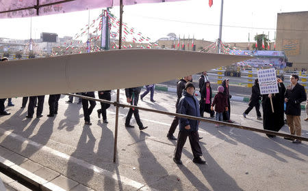 FILE PHOTO: People walk near an Iranian-made missile during a ceremony marking the 37th anniversary of the Islamic Revolution, in Tehran February 11, 2016. REUTERS/Raheb Homavandi/File Photo