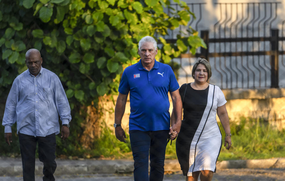 Cuba's President Miguel Diaz Canel walks with his wife Lis Cuesta Peraza before casting his vote at a polling station during the new Family Code referendum in Havana, Cuba, Sunday, Sept. 25, 2022. The draft of the new Family Code, which has more than 480 articles, was drawn up by a team of 30 experts, and it is expected to replace the current one that dates from 1975 and has been overtaken by new family structures and social changes. (AP Photo/Ramon Espinosa)