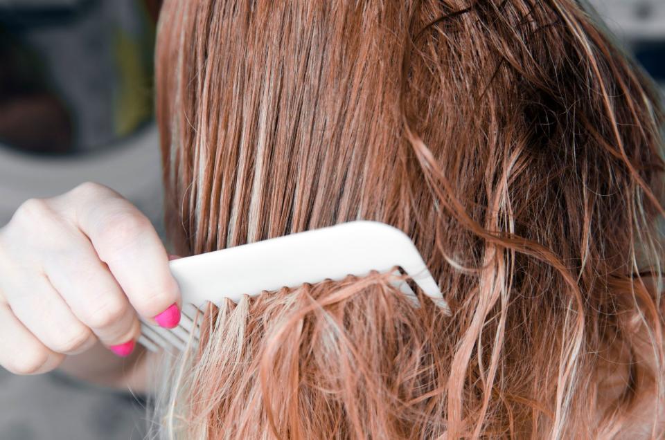 Vor der Haarwäsche sollten die Haare sorgfältig und gut durchgekämmt oder ausgebürstet werden, um Stylingreste und Schmutz vorab zu entfernen. Dadurch wird die Haarwäsche effizienter. Auch verknotete und verhedderte Haare werden so entwirrt. Beim Waschen würden sich ungekämmte Haare sogar noch mehr verknoten, was wiederum zu Spliss oder Haarbruch führen kann. (Bild: iStock/Biserka Stojanovic)