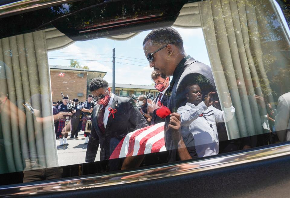 Law enforcement officers salute as Larry Courts Jr., foreground, and others carry the casket of his brother fallen Detroit Police Officer Loren Courts on Monday, July 18, 2022, at the end of his funeral at Greater Grace Temple in Detroit.