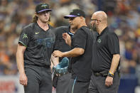 Tampa Bay Rays starting pitcher Ryan Pepiot, left, is taken out of the game against the New York Mets by manager Kevin Cash, center, and trainer Joe Benge after getting hit on the foot by a ground ball by New York Mets' Starling Marte during the third inning of a baseball game Sunday, May 5, 2024, in St. Petersburg, Fla. (AP Photo/Chris O'Meara)