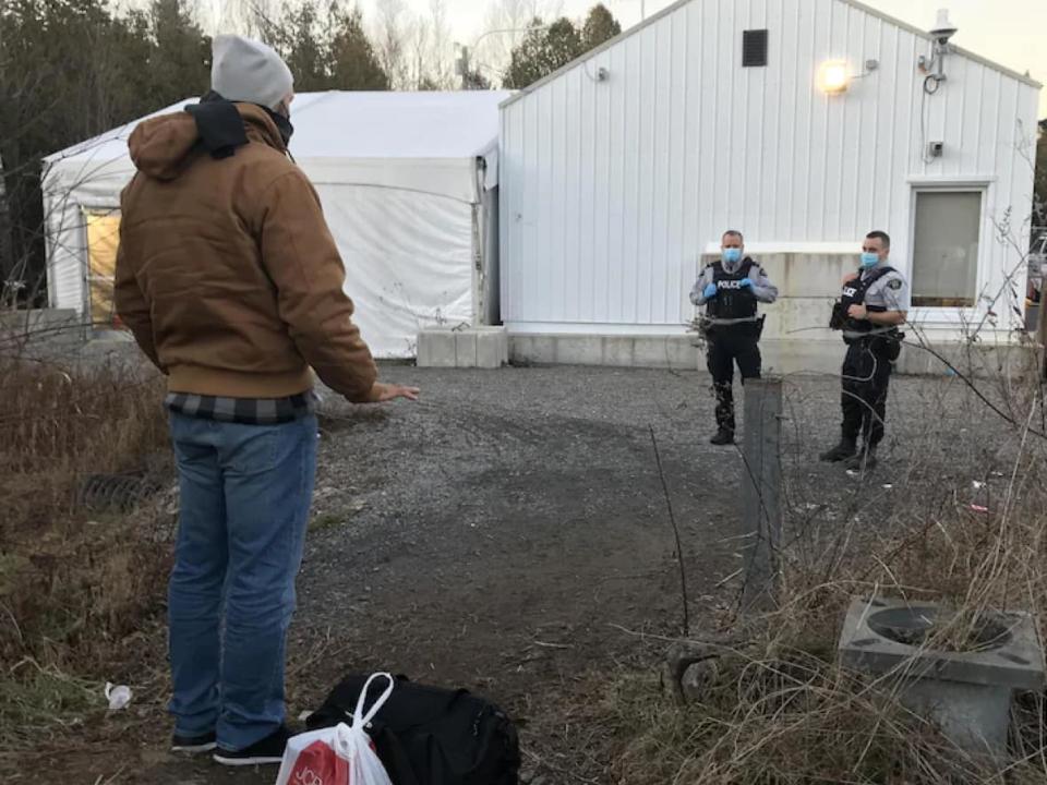 An asylum seeker at the Roxham Road crossing in Quebec. Radio-Canada sources say several U.S. border patrol agents are giving migrants lifts to an irregular border crossing into Canada as a side business.  (Romain Schué/Radio-Canada - image credit)