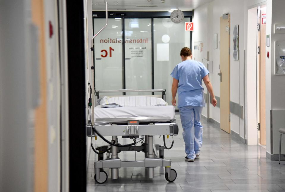 A medical staff member walks past an empty bed on an intensive care unit (ICU) at a hospital in Salzburg, Austria, on Nov.  17, 2021.