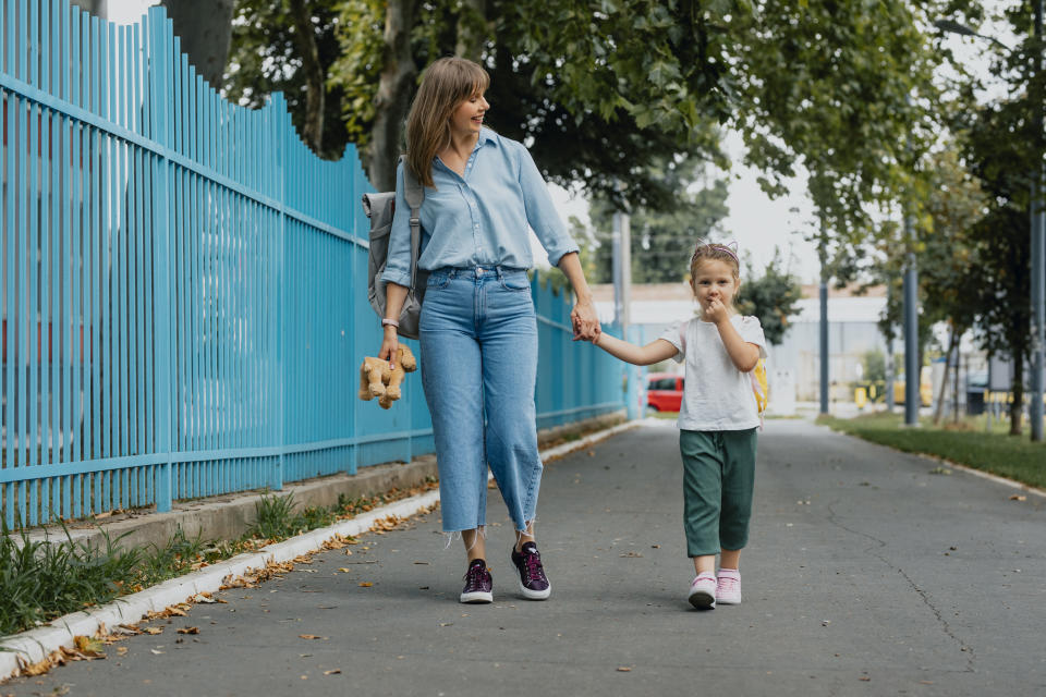 Mother and daughter walking together, holding hands.