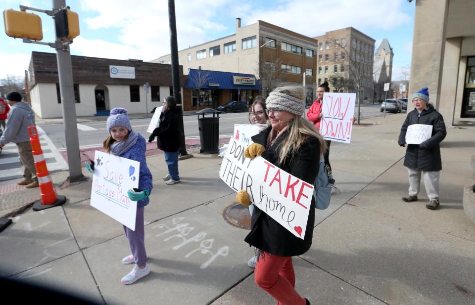 Kris Borkowski and others stand with signs at Lafayette and Jefferson boulevards on Tuesday, March 14, 2023, at the County-City Building in downtown South Bend. About a dozen people hold signs seeking a delay in the decision by county officials to decide the fate of Portage Manor in South Bend.