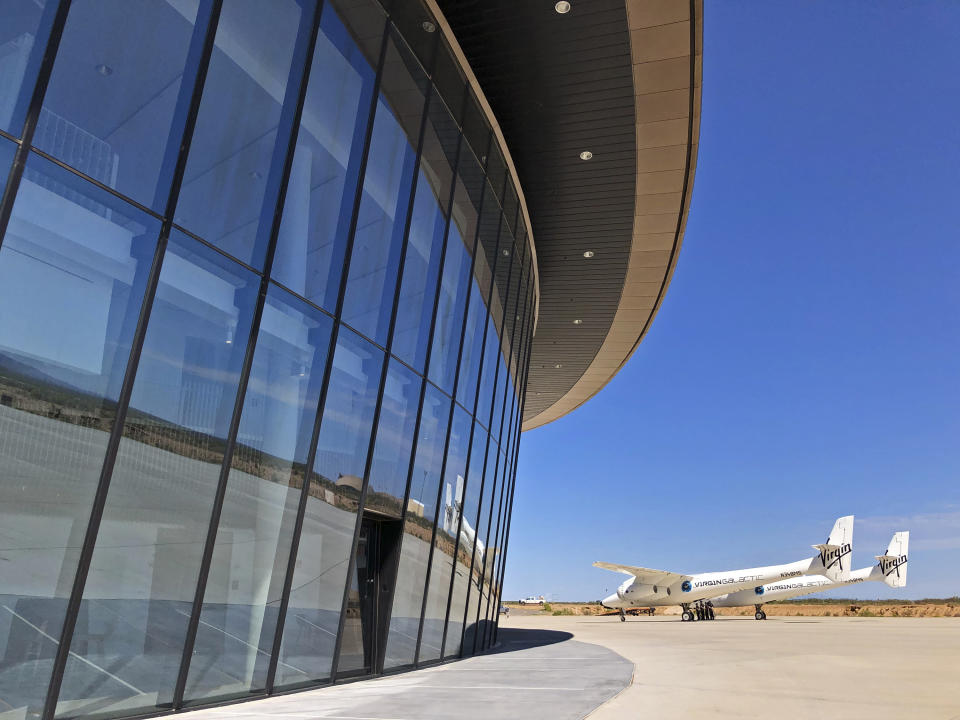 Virgin Galactic's carrier plane makes its way across the apron in front of Spaceport America following a test flight over its new permanent home near Upham, New Mexico, on Thursday, Aug. 15, 2019. Virgin Galactic on Thursday unveiled two levels of its new digs at the spaceport, which includes a social hub where crew, pilots and customers and their families can mingle. (AP Photo/Susan Montoya Bryan)