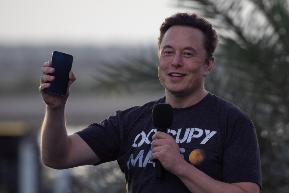 SpaceX Chief Engineer Elon Musk raises his phone during a joint news conference with T-Mobile CEO Mike Sievert at the SpaceX Starbase, in Brownsville, Texas, U.S., August 25, 2022. REUTERS/Adrees Latif