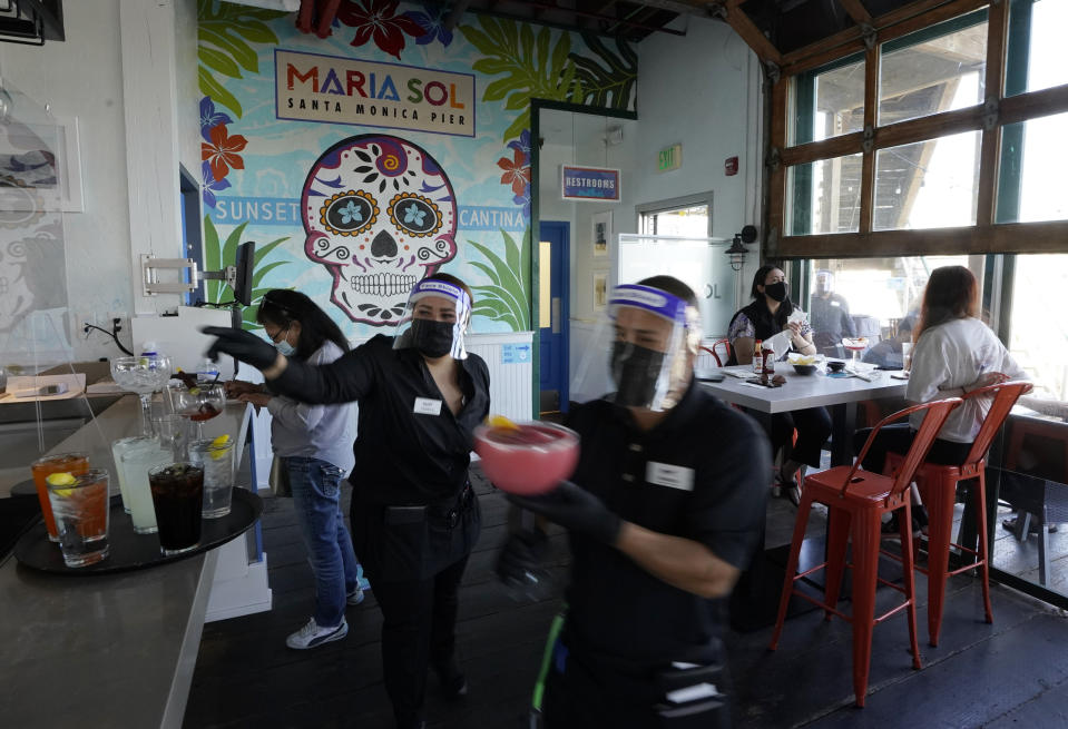 People have drinks indoors at Maria Sol on the Santa Monica Pier as they open for indoors service in Santa Monica, Calif., Wednesday, March 31, 2021. Los Angeles County can reopen even more businesses while expanding how many people are allowed to dine indoors or catch a movie, California public health officials announced Tuesday, March 30. The county of 10 million people was one of several that moved into the state's orange tier, which is the second-least restrictive of California's four-tier system. (AP Photo/Damian Dovarganes)