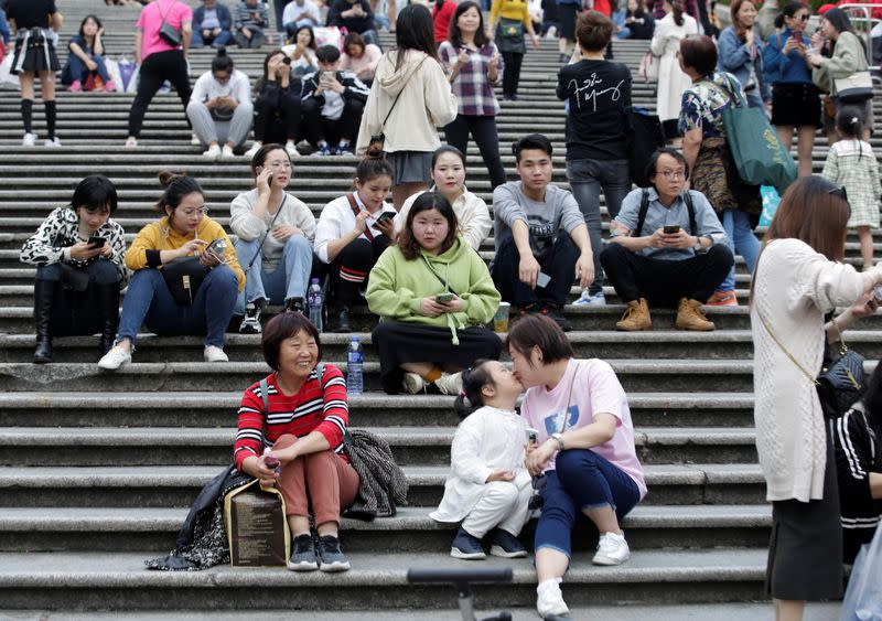 Tourists rest in front of the Ruins of St. Paul's in Macau