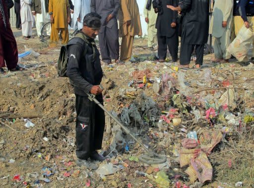 A bomb disposal expert checks the site of a bomb explosion at Dera Ismail Khan in Khyber Pakhtunkhwa province on Saturday. A bomb blast claimed by the Taliban killed eight people near a Shiite Muslim procession in northwest Pakistan on Saturday, in the latest attack against the minority during their holy month