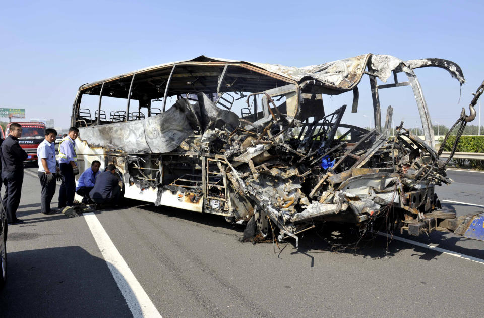 In this photo released by China's Xinhua News Agency, the wreckage of a bunt-out bus sits on an expressway near Tianjin, China, Monday, Oct. 1, 2012. Five Germans and a Chinese citizen were killed when the bus burst into flames after hitting the back of a truck Monday, Xinhua said. (AP Photo/Xinhua, Yue Yuewei) NO SALES