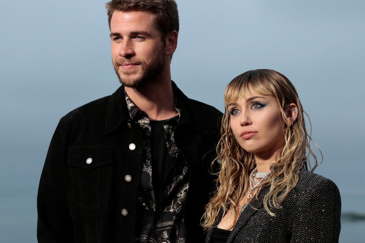 US singer Miley Cyrus and husband Australian actor Liam Hemsworth arrive for the Saint Laurent Men's Spring-Summer 2020 runway show in Malibu, California, on June 6, 2019. (Photo by Kyle GRILLOT / AFP)        (Photo credit should read KYLE GRILLOT/AFP/Getty Images)