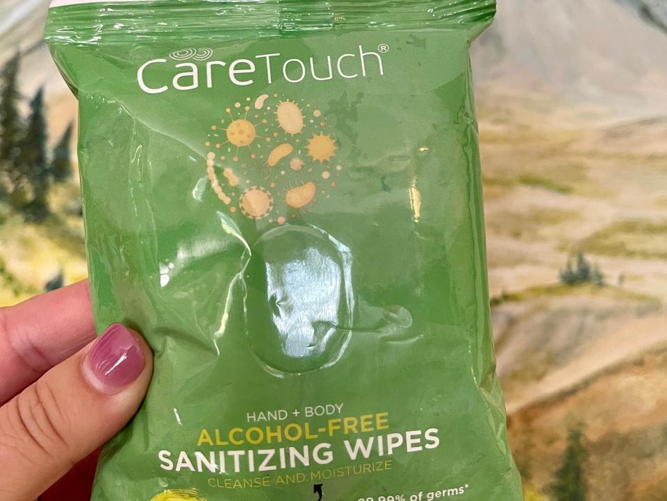 hand holding pack of sanitizing wipes