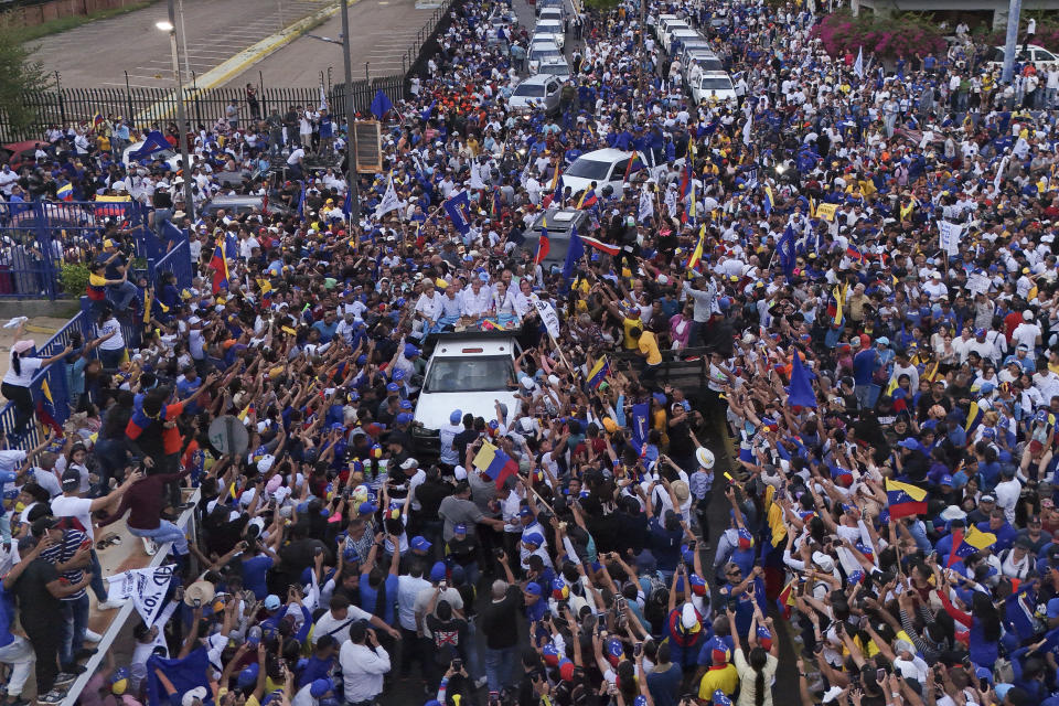 El candidato presidencial Edmundo González, centro, y la líder opositora María Corina Machado, centro derecha, saludan a sus partidarios durante un mitin de campaña en Maracaibo, Venezuela, el martes 23 de julio de 2024. (AP Foto/Matías Delacroix)