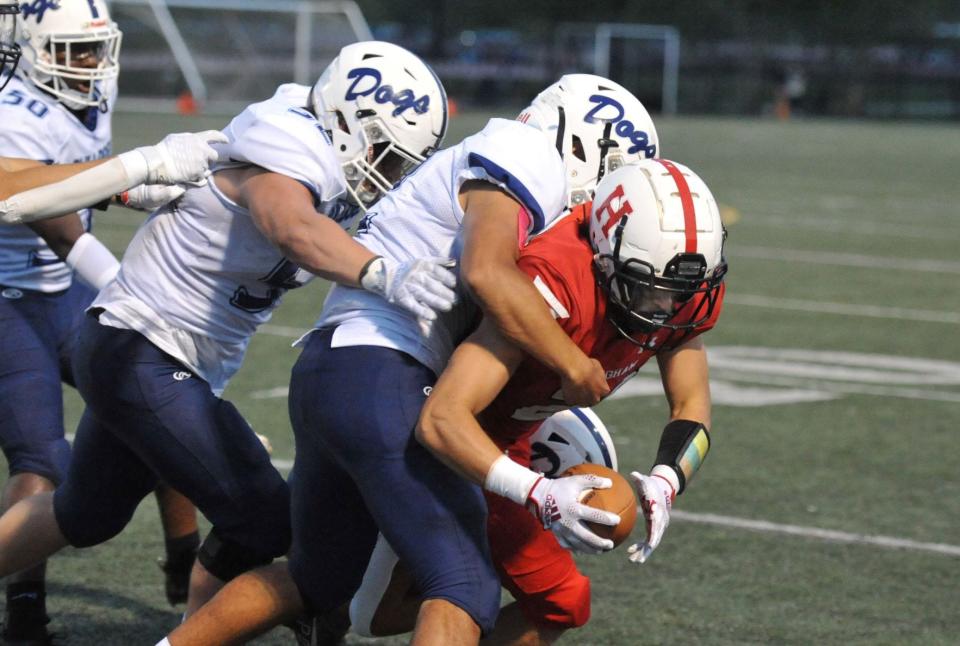 Hingham's William St. Pierre, right, is taken down by Rockland's Leary Costa, left, and Jordan DePina, center, during the high school football season season opener at Hingham High School, Friday, Sept. 9, 2022.