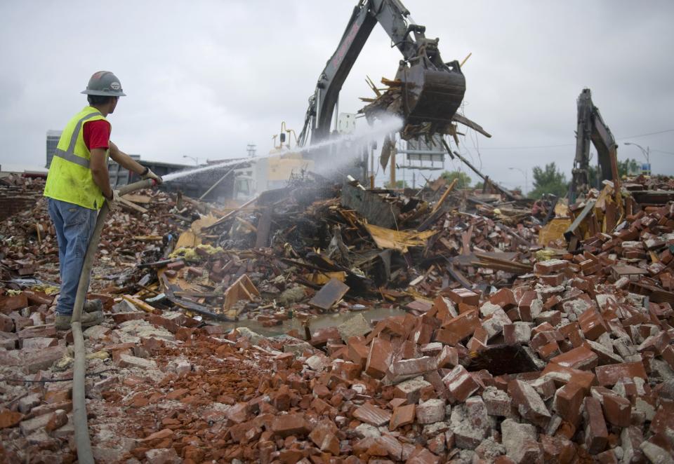 A worker sprays down rubble to keep the dust down as two trackhoes clear debris from the demolition site of Harpole's at Main and John streets in 2016. The nearly 125-year-old building was finally razed after sitting dormant since a fire gutted it in 2009.