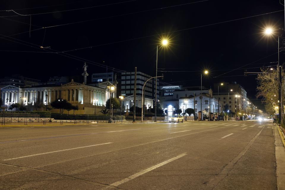 In this Thursday, April 2, 2020 photo, a view of the empty Panepistimiou street by the Athens Academy during the lockdown. Deserted squares, padlocked parks, empty avenues where cars were once jammed bumper-to-bumper in heavy traffic. The Greek capital, like so many cities across the world, has seen its streets empty as part of a lockdown designed to stem the spread of the new coronavirus. (AP Photo/Thanassis Stavrakis)