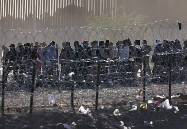 Migrantes esperan en las márgenes del Río Grande en el sector que da al cruce de El Paso, Texas, desde Ciudad Juarez, Méxic. (HERIKA MARTINEZ / AFP)