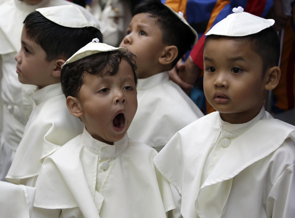 A boy dressed as a Pope, yawns as he prepares to join a parade in celebration of the canonization or the elevation to sainthood in the Vatican of Roman Catholic Pope John Paul II and Pope John XXIII Sunday, April 27, 2014, at suburban Quezon city, northeast of Manila, Philippines. Pope Francis declared his two predecessors John XXIII and John Paul II saints on Sunday before hundreds of thousands of people in St. Peter's Square, an unprecedented ceremony made even more historic by the presence of retired Pope Benedict XVI. The predominantly Roman Catholic Philippines joins several nations worldwide in the celebration of canonization of the two Popes. (AP Photo/Bullit Marquez)