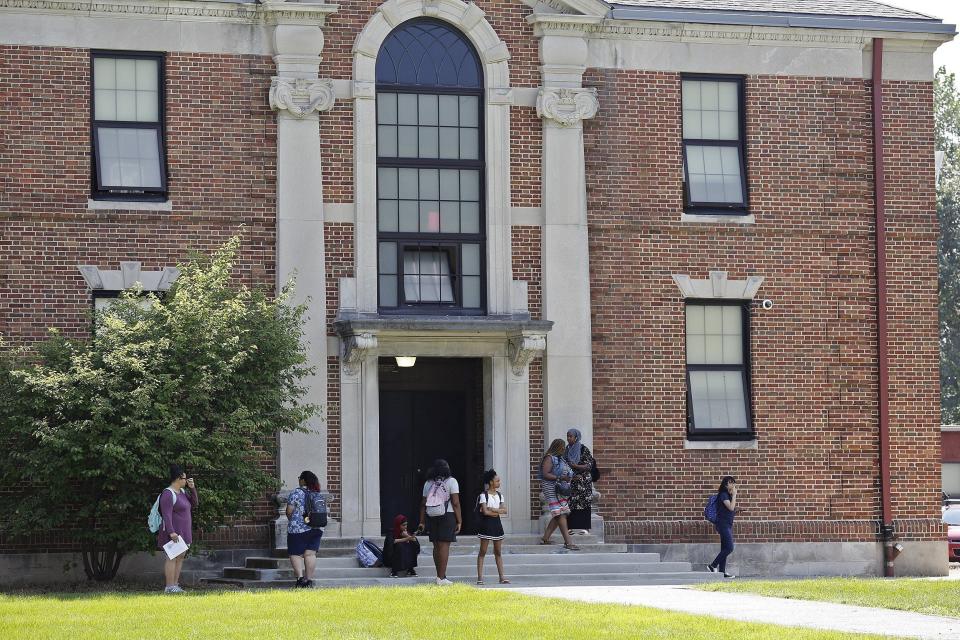 Students stand outside Columbus Alternative High School on Aug. 28, 2018, in this Dispatch file photo. On that day, Columbus City Schools dismissed students from classes early because of the heat. The district is now in the process of relaunching its facilities master plan, which is expected to recommend replacing the nearly 100-year-old building, which isn't fully air-conditioned. [Kyle Robertson/Dispatch file photo]