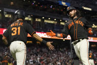 San Francisco Giants' LaMonte Wade Jr., left, celebrates with Brandon Crawford after both scored on a two-run single by Curt Casali during the fourth inning of the team's baseball game against the Atlanta Braves in San Francisco, Saturday, Sept. 18, 2021. (AP Photo/Jeff Chiu)