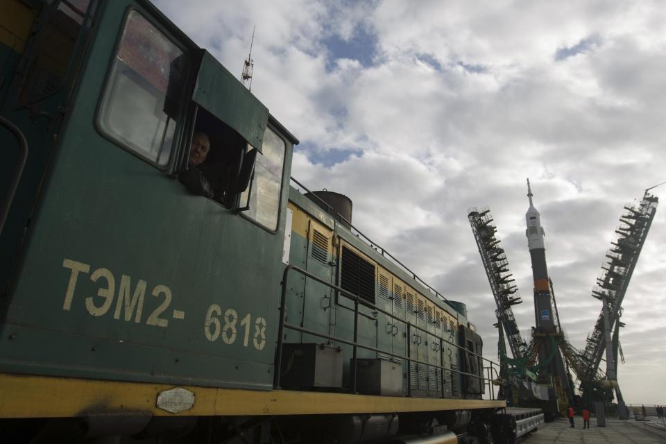 A locomotive operator looks out of the window as the Soyuz TMA-12M spacecraft is set on its launch pad at the Baikonur cosmodrome