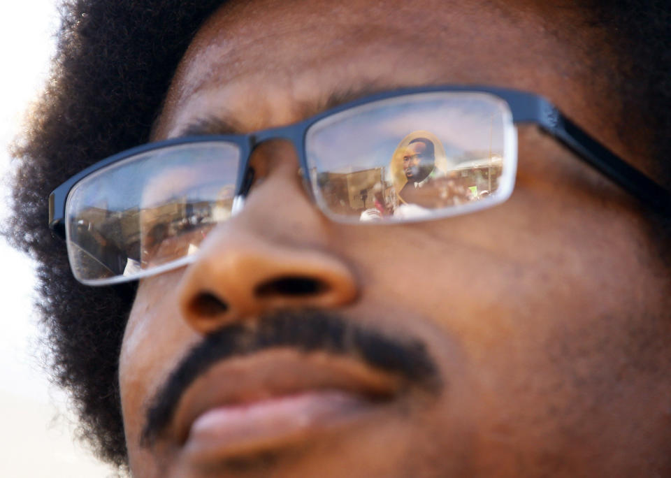 FILE - An image of Martin Luther King, Jr., is reflected in Justin Pearson's glasses before a march with supporters to the Shelby County Board of Commissioners meeting in Memphis, Tenn., on Wednesday, April 12, 2023. Two young Black Tennessee state legislator Justin Pearson and Justin Jones — now widely known simply as "the Justins" — were expelled by the overwhelmingly white, Republican-controlled state Legislature and then reinstated by local officials days later. They are being heralded as living echoes of the civil rights struggles of the 1960s, when leaders like the Rev. Martin Luther King Jr., John Lewis and A. Philip Randolph organized protests across the American South. (Chris Day/The Commercial Appeal via AP, File)