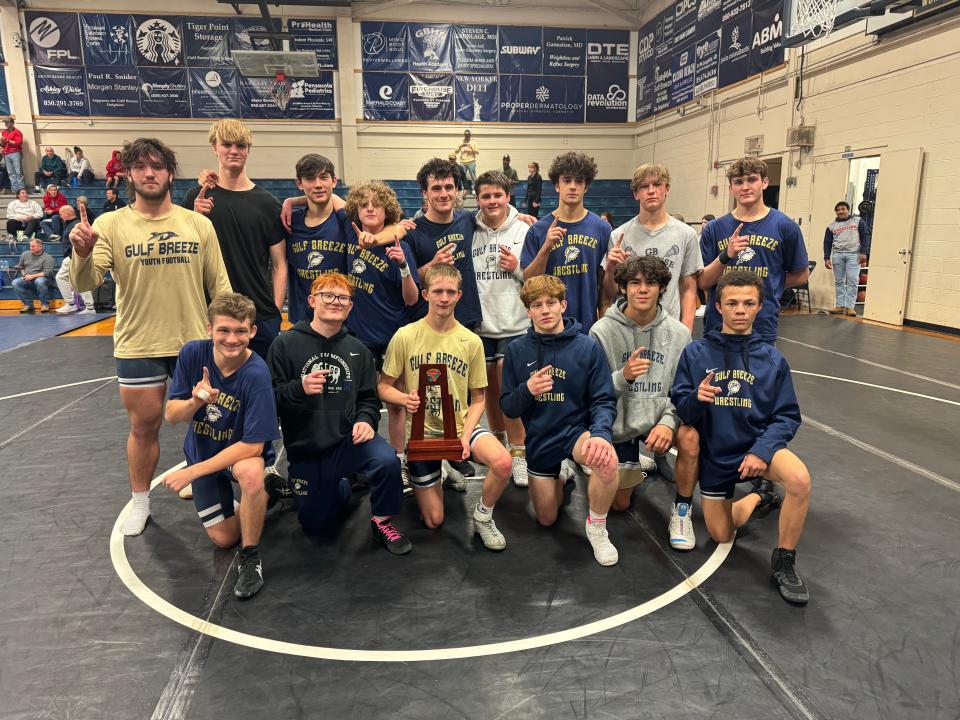 The Gulf Breeze wrestling team poses with its newest trophy, the District 1-2A Duals tournament trophy, after beating Fort Walton Beach on Wednesday, Jan. 3, 2024, at Gulf Breeze High School.