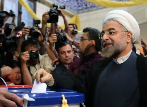 Hassan Rowhani casts his vote at a polling station in Tehran on June 14, 2013. Rowhani, bolstered by a late surge in support from suppressed Iranian reformists, took an early lead in the presidential election to find a successor to Mahmoud Ahmadinejad, initial results showed Saturday