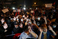 Anti-government protesters gesture, outside the Criminal court during a protest in Bangkok, Thailand, Saturday, March 6, 2021. A new faction of Thailand's student-led anti-government movement calling itself REDEM, short for Restart Democracy, announced plans to march to Bangkok's Criminal Court Saturday to highlight the plight of several detained leaders of the protest movement. (AP Photo/Sakchai Lalit)