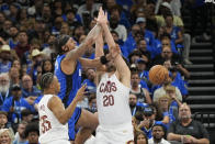 Orlando Magic forward Paolo Banchero loses the ball as he gets caught between Cleveland Cavaliers forward Isaac Okoro, left, and forward Georges Niang (20) during the first half of Game 6 of an NBA basketball first-round playoff series, Friday, May 3, 2024, in Orlando, Fla. (AP Photo/John Raoux)