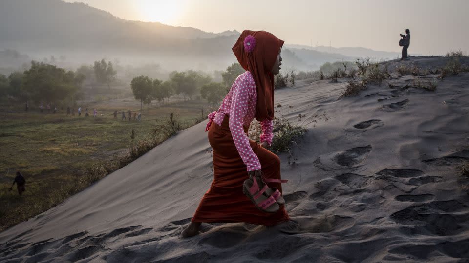A Muslim woman walks on "sea of sands" as she prepares for prayer at Parangkusumo Beach in Yogyakarta, Indonesia.  - Ulet Ifansasti/Getty Images