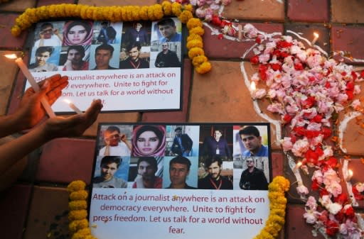 An Indian photojournalist in Kolkata holds a candle during a vigil for the 10 Afghan journalists killed in Monday's suicide bombing