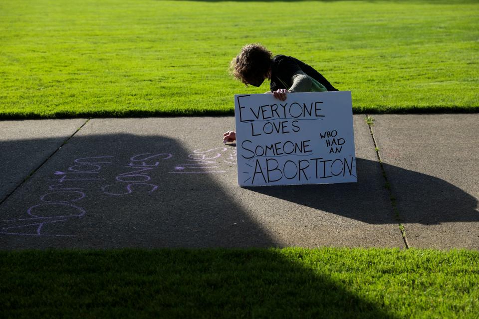 A person writes an abortion-rights message on the sidewalk as people gather to oppose the possible overturning of federal abortion protections following the leaked draft of a U.S. Supreme Court opinion, at Riverfront Park in Salem, Ore., on Tuesday, May 3, 2022.