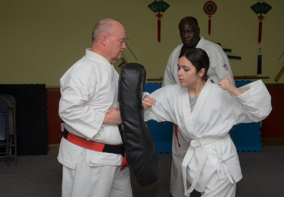 Lucy Sabitt, 13, works out with Sensei David Harris, a fourth-degree black belt, at the New Bern School of Martial Arts last week.