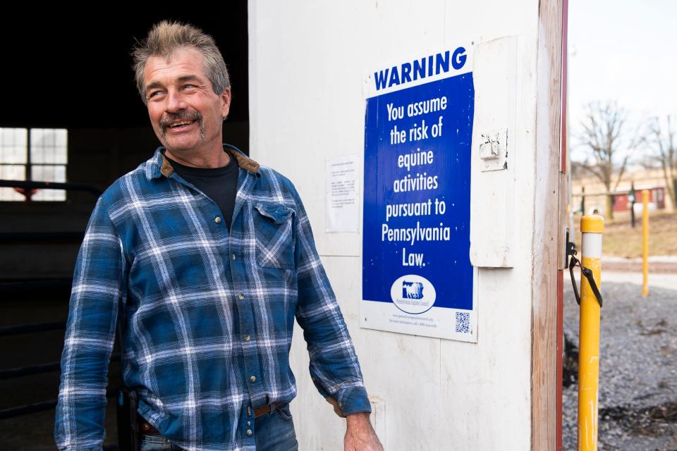 Marty Petratos smiles while standing outside the enclosed round pen at Central Pa. Horse Rescue, near Lewisberry, in February 2022. Petratos built the pen by hand and the rescue uses it as an indoor training facility for the horses.