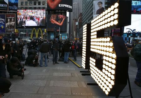 The New Year's Eve "15" numerals stand lit on the sidewalk after they were unloaded from a truck in Times Square in New York, December 16, 2014. REUTERS/Mike Segar