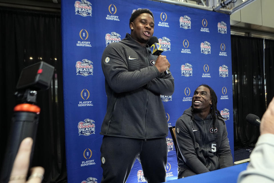 Georgia defensive lineman Warren Brinson, left, interviews defensive back Kelee Ringo (5) during media day for the Peach Bowl NCAA college football game against Ohio State, Thursday, Dec. 29, 2022, in Atlanta. (AP Photo/John Bazemore)