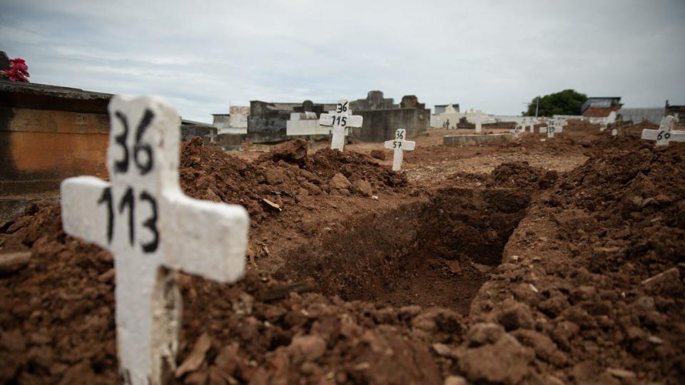 Ein einfaches Kreuz ohne Namen und mit einer Nummer steht an einem offenen Grab am Friedhof von Iraja in Rio de Janeiro.