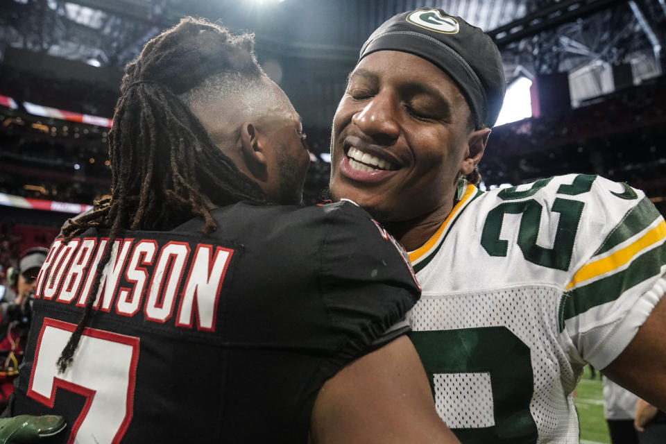 Atlanta Falcons running back Bijan Robinson (7) embraces Green Bay Packers cornerback Rasul Douglas (29) after an NFL football game, Sunday, Sept. 17, 2023, in Atlanta. The Atlanta Falcons won 25-24. (AP Photo/Brynn Anderson)