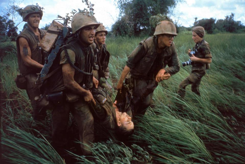 Caption from LIFE. "Four Marines recover the body of a fifth as their company comes under fire near Hill 484." Vietnam, October 1966. NOTE: At right is the French-born photojournalist Catherine Leroy (1945 – 2006); she was cropped out of the version of this photo that originally ran in LIFE. (Larry Burrows—Time & Life Pictures/Getty Images) <br> <br> <a href="http://life.time.com/history/life-behind-the-picture-larry-burrows-reaching-out-1966/#1" rel="nofollow noopener" target="_blank" data-ylk="slk:Click here to see the full collection at LIFE.com;elm:context_link;itc:0;sec:content-canvas" class="link ">Click here to see the full collection at LIFE.com</a>